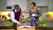 Mutter und Vater helfen einem Jungen bei seinen Hausaufgaben.  