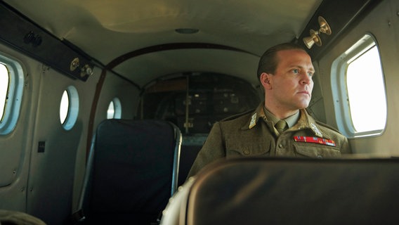 Szenenbild aus der norwegischen Serie "Atlantic Crossing": Ein Mann in Uniform sitzt in einem Flugzeug. © NDR/Julie Vrabelová 