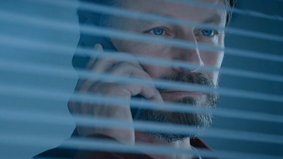 Szenenbild aus der Serie "Helsinki-Syndrom": Ein Mann hält ein Telefon in der Hand. © NDR/Fisher King Oy/Kimmo Korhone 