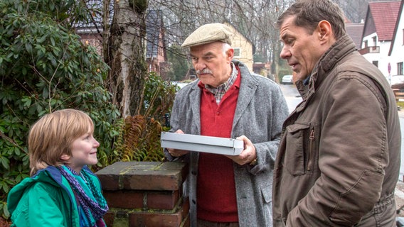 Finn Kiesewetter (Sven Martinek, r.) spricht mit Luca Niemann (Lennox Krause, l.) und Opa Fischer (Charles Brauer, M.), dem Sohn und Vater der verstorbenen Patientin von Dr. Unger, Ute Niemann. © NDR/ARD/Georges Pauly 