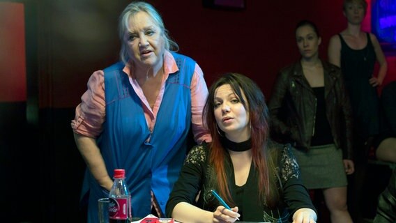 Szenenbild aus der Comedy-Serie "Jennifer - Sehnsucht nach was Besseres": Oma Magret (Doris Kunstmann) und Jennifer (Katrin Ingendoh) schauen sich die Tänzerinnen an. © NDR/Georges Pauly 