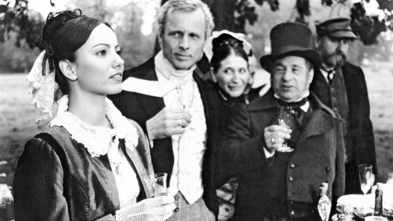 Mit Fassung ertragen Frieda (Marietta Schupp, links) und Axel von Rambow (Rolf Becker, daneben) die scheinheiligen Glückwünsche der Eheleute Pomuchelskopp (Helga Feddersen und Joachim Wolff) zur missglückten Vorführung. © NDR/Hassenstein 