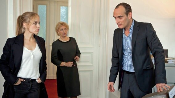 Die Immobilienmaklerin Eva Reich ist im Keller eines ihrer Mitshäuser an einem Stromschlag gestorben. Julia Klug (Friederike Kempter, l.) befragt ihren Ehemann und Teilhaber Dietmar Kuhn (Anatole Taubman, r.) in Gegenwart von Frau Böhm (Katarina Tomaschewski, M.) nach seinem Alibi. © NDR/ARD/Daniela Incoronato 