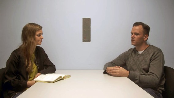 NDR Autorin Caroline Rollinger (l.) sitzt Robert W. an einem Tisch gegenüber. © NDR 
