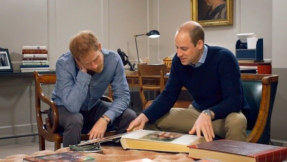 Prinz Harry und Prinz William schauen sich ein Fotoalbum an. © NDR/Oxford Film & Television 