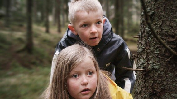 Robin (Erlend Böe) und Kaja (Synne Stensgård) beobachten, wie im Wald ein Gewehr versteckt wird. © NDR/NordicStories 