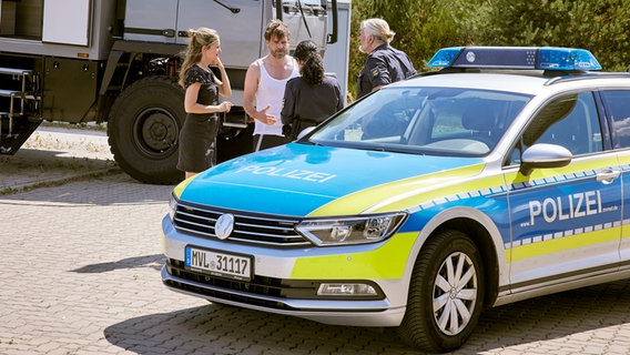 Szenenbild aus der NDR Serie "Retoure": Polizeieinsatz am Retourencenter: Oliver Drittenpreis (Wanja Mues), Susanne Krombholz (Stefanie Stappenbeck), die Polizisten Gabi (Şafak Şengül) und Peter (Frank Kessler). © NDR/Kinescope Film/O-Young Kwon 