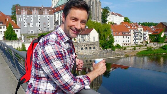 In Görlitz beginnt Moderator Marco Schreyl seine Reise nach Krakau. Die kleine Fußgängerbrücke über die Neiße verbindet Deutschland mit Polen. © NDR/WDR/Per Schnell 