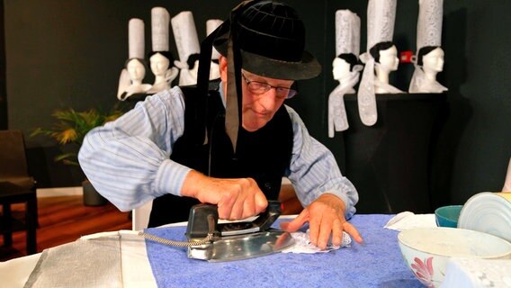 Michel Bolzer bügelt traditionelle Hauben in Pont l’Abbé. © NDR/Miramedia 