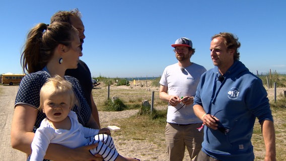 Eingefleischte Camper: Jens Köhler und Johannes Vieten zeigen den Urlaubern aus Augsburg ihren Stellplatz mit © NDR 