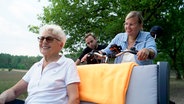 Beim Projekt "Radeln ohne Alter" tritt Martina in der Lüneburger Heide selbst in die Pedale: Marwin Fischer erzählt ihr viel über seine Erfahrung mit begeisterten Seniorinnen und Senioren, die sich in den Rikschas richtig wohl fühlen. © NDR 