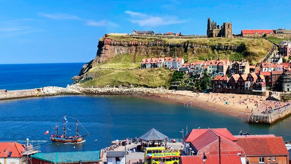 Das malerische Örtchen Whitby, über dessen Hafen die Whitby Abbey wacht. Hier startete die Christianisierung Englands. Und der Entdecker James Cook lernte hier das Segeln. Das malerische Örtchen Whitby, über dessen Hafen die Whitby Abbey wacht. Hier startete die Christianisierung Englands. Und der Entdecker James Cook lernte hier das Segeln. © NDR / MANFRED SCHULZ TV / FilmProduktion