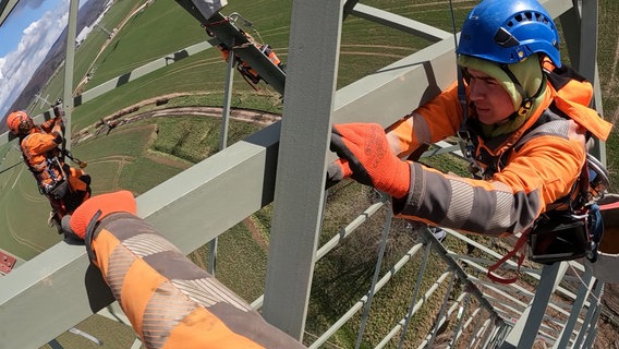 Mastbau an der A7. Acht Stunden lang hämmern die Kletterer heute auf dem Mast die vormontierten Bauteile zusammen. © NDR/Filmblick Hannover 