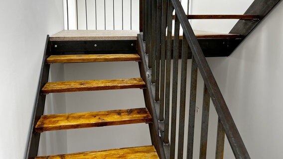 Die Stahltreppe mit Stufen aus alten Gerüstbohlen führt von Erdgeschoss über das Obergeschoss bis ins Dachgeschoss. © NDR/Rainer Mueller-Delin 