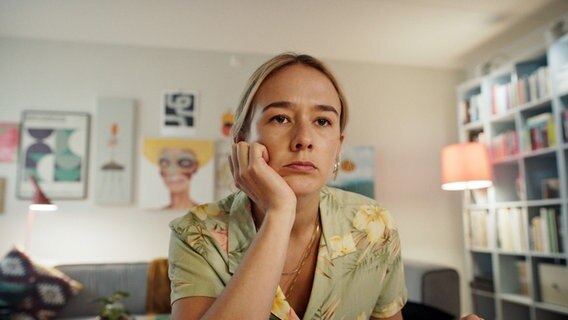 Szenenbild aus der schwedischen Serie "Everyone but us": Eine Frau sitzt mit aufgestützen Kopf am Tisch. © Warner Bros International 