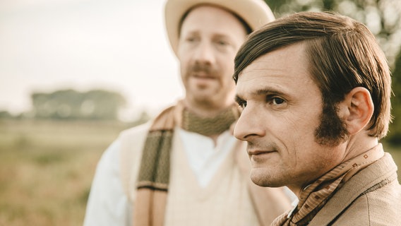 Schauspieler Florian Lukas als Heinrich Vogeler (vorne im Bild) und Johann von Bülow als Rainer Maria Rilke (hinten im Bild, unscharf). Vogeler und Rilke pflegten eine jahrelange Freundschaft und haben sich in der Künstlerkolonie in Worpswede kennengelernt. Schauspieler Florian Lukas als Heinrich Vogeler (vorne im Bild) und Johann von Bülow als Rainer Maria Rilke (hinten im Bild, unscharf). Vogeler und Rilke pflegten eine jahrelange Freundschaft und haben sich in der Künstlerkolonie in Worpswede kennengelernt. © NDR/Benjamin Eichler