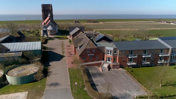 Direkt hinter Pellworms Wahrzeichen, der Alten Kirche, steht das neue Hotel "NordseeLodge". © NDR 