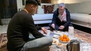 Shahab hat Axel Limberg zu einem traditionellen afghanischen Essen eingeladen. © NDR/stennerfilm GmbH & Co KG/Kristina Forbat 