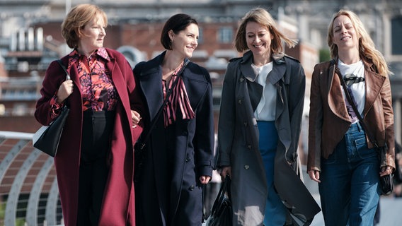 Szenenbild aus der Serie "The Split - Beziehungsstatus ungeklärt": Vier Frauen laufen nebeneinander her auf einer Brücke. © Sister Pictures 