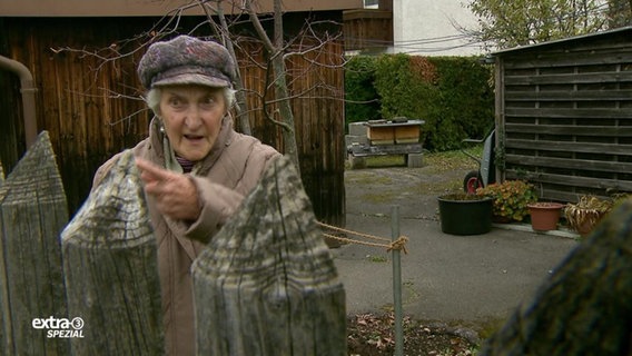 Ältere Dame zeigt mit dem Zeigefinger auf etwas was sie empört  
