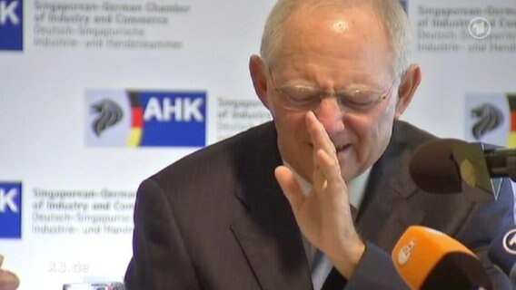 Schäuble auf einer Pressekonferenz verzieht das Gesicht und macht eine abwinkende Handbewegung  