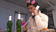 Christian Ehring mit Lockenwickler inm Haar am Telefon  