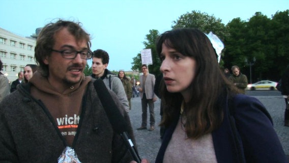 Die NDR-Reporterin Caro Korneli interviewt einen Demonstranten.  