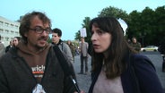 Die NDR-Reporterin Caro Korneli interviewt einen Demonstranten.  