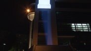 Ein lichtstarker Beamer projiziert etwas auf die Häuserfassade der SPD-Zentrale © NDR 
