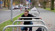 Der Kleefelder Bezirksbürgermeister Henning Hofmann betrachtet einen der neuen Fahrradbügel.  