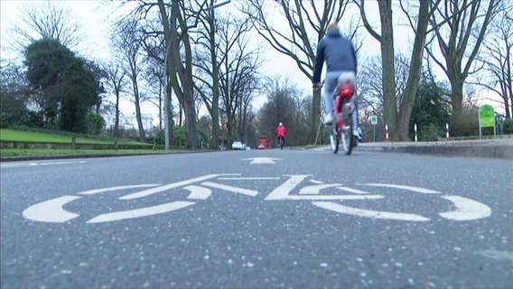 Ein Fahrrad-Symbol auf dem Asphalt markiert einen Radweg. Ein Fahrrad-Symbol auf dem Asphalt markiert einen Radweg.