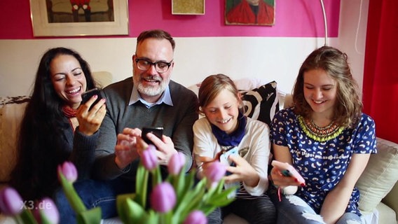 Eine Familie an ihren Handys.  