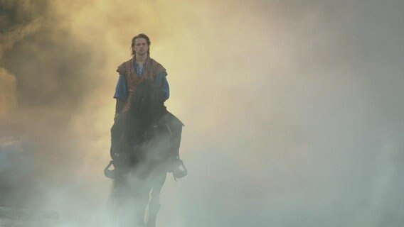 Störtebeker-Schauspieler reitet auf einem Pferd in die Tribüne.  