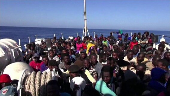 Aufnahme von Flüchtlingen auf einem völlig überfüllten Boot.  