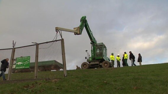 Ein Kran reißt den Zaun des Freihafens ab. © NDR 