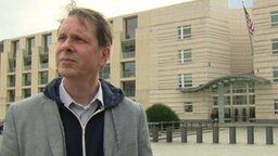 ARD-Reporter John Goetz steht vor der amerikanischen Botschaft in Berlin.  