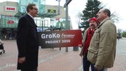 Zwei Männer halten eine Werbeschild für die GroKo  