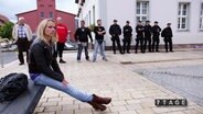 Stefanie Gromes sitzt nachdenklich auf einer Bank.  
