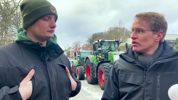 Ministerpräsident Daniel Günther von der CDU sucht das Gespräch mit einem demonstrierenden Landwirt. © NDR Foto: NDR Screenshot