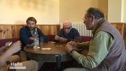 Tobi Hartmann sitzt inmitten einer Skatrunde.  
