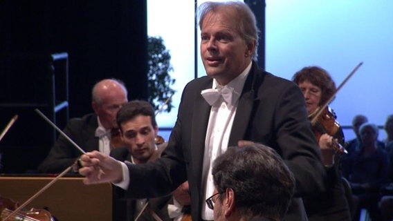 Dirigent Thomas Hengelbrock dirigiert ein Orchester.  