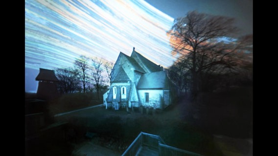 Haus mit bunten Schlieren am Himmel. © Volkmar Herre 