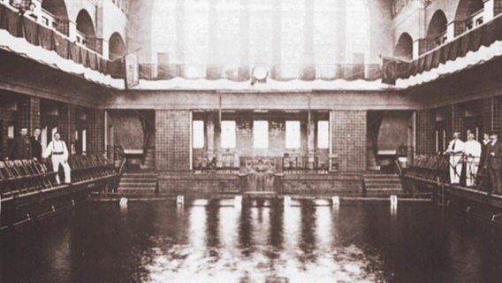 Eine alte Schwarzweißfotografie zeigt das Holthusenbad von innen.  