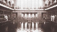 Eine alte Schwarzweißfotografie zeigt das Holthusenbad von innen.  
