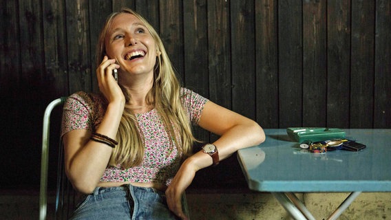 Jeanny (Therese Riess) telefoniert lachend mit Johannes. © MDR/ORF/Rowboat/Anjeza Cikopano 