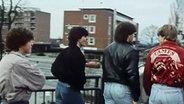Vier Jugendliche in den Achtzigern laufen über eine Brücke. © NDR 