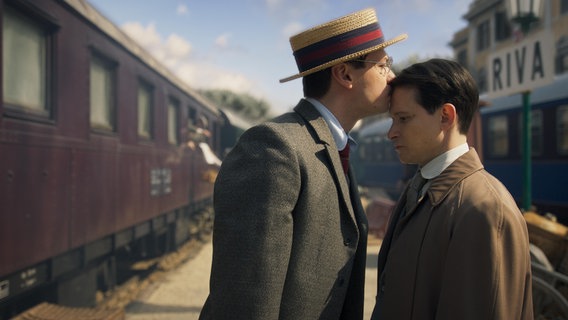 Max Brod (David Kross) küsst Franz Kafka (Joel Basman) an einem Bahnsteig auf die Stirn. © Nicole Albiez 