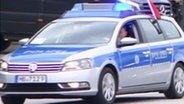Ein Polizeiwagen führt eine Fahrzeugkolonne an  