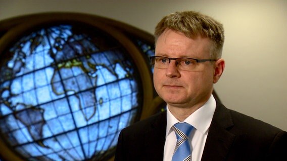 Stefan Kooths vom Institut für Weltwirtschaft in Kiel sitzt vor einer Wand und gibt ein Interview. © Screenshot 