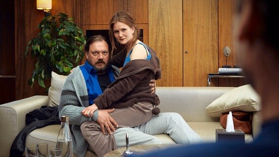 Szenenbild aus der Impro-Serie "Kranitz - Bei Trennung Geld zurück": Ein Paar sitzt auf einem Sofa. © ARD Degeto/NDR/Thomas Leidig 